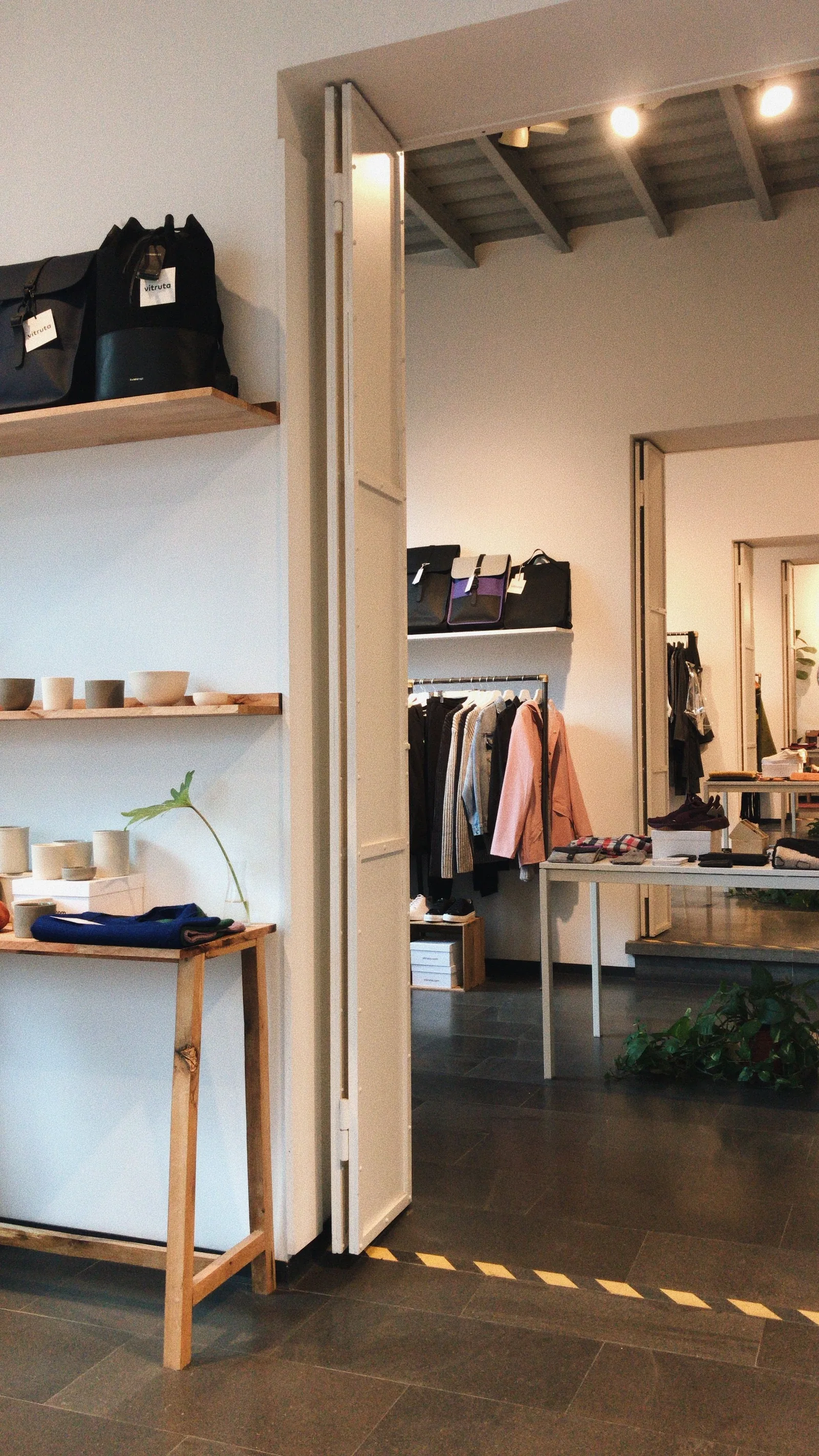 Boutique mit mehreren Verkaufsbereichen, Regalen, Kleidung und Nebenflächen
