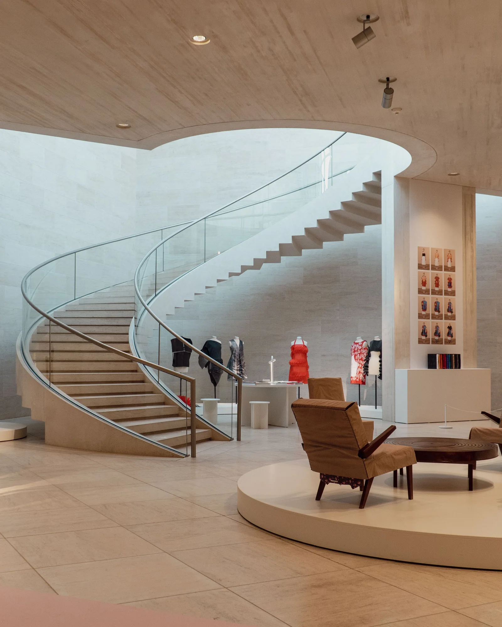 Großzügiges Modegeschäft mit geschwungener Treppe, Präsentationsflächen und Sitzbereich